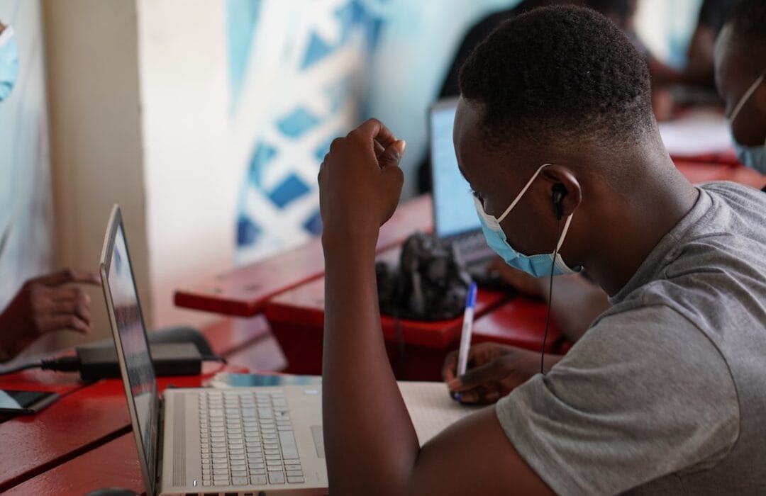 Cybersecurity Ghana 2026 — a Ghanaian business professional reviewing cyber threat alerts on a laptop in an Accra office